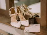 Bridal high heels, Jo Malone perfume, engagement ring and wedding invitation beside a hotel room mirror.