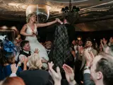 Couple being held up on chairs after ceremony