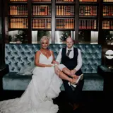 bride and groom sitting on upholstered suite inside boclair house