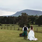 Couple walking in field after being married at Cornhill Castle