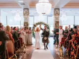 newly married couple walking down aisle in boclair wedding venue hall