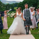 Couple walking down the aisle through confetti