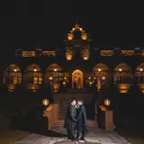 newly married couple in front of boclair wedding venue lit up at night