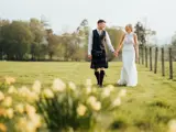 couple walking in field after intimate wedding in scotland