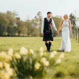 couple walking in field after intimate wedding in scotland