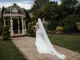 o	Bride and groom walking towards ornate gazebo in beautiful gardens of Scottish venue with late availability wedding packages.