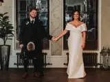 Couple holding hands in front of ornate windows in the hallway of Cornhill Castle