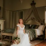Bride dressed on bed in Honeymoon Suite
