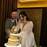 Couple smiling and cutting their cake