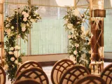 Wedding ceremony setup in Boclair House Grand Ballroom in Bearsden, Glasgow, with mirrored pillars, gold chandeliers, and white aisle.
