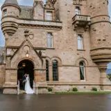 Couple kissing at castle entrance