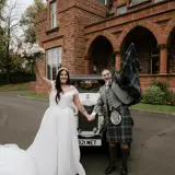 Couple posing in front of Wedding Car