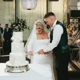 bride and groom cutting 3 layer wedding cake on wedding day