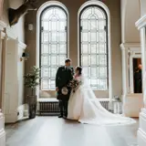 Couple infront of ornate window in hallway
