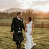 Couple walking in field after wedding