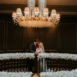 Couple sharing a kiss in the stairwell of Boclair House