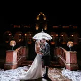 Couple under umbrella outside of Boclair House