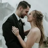 Couple looking lovingly under a brides vail